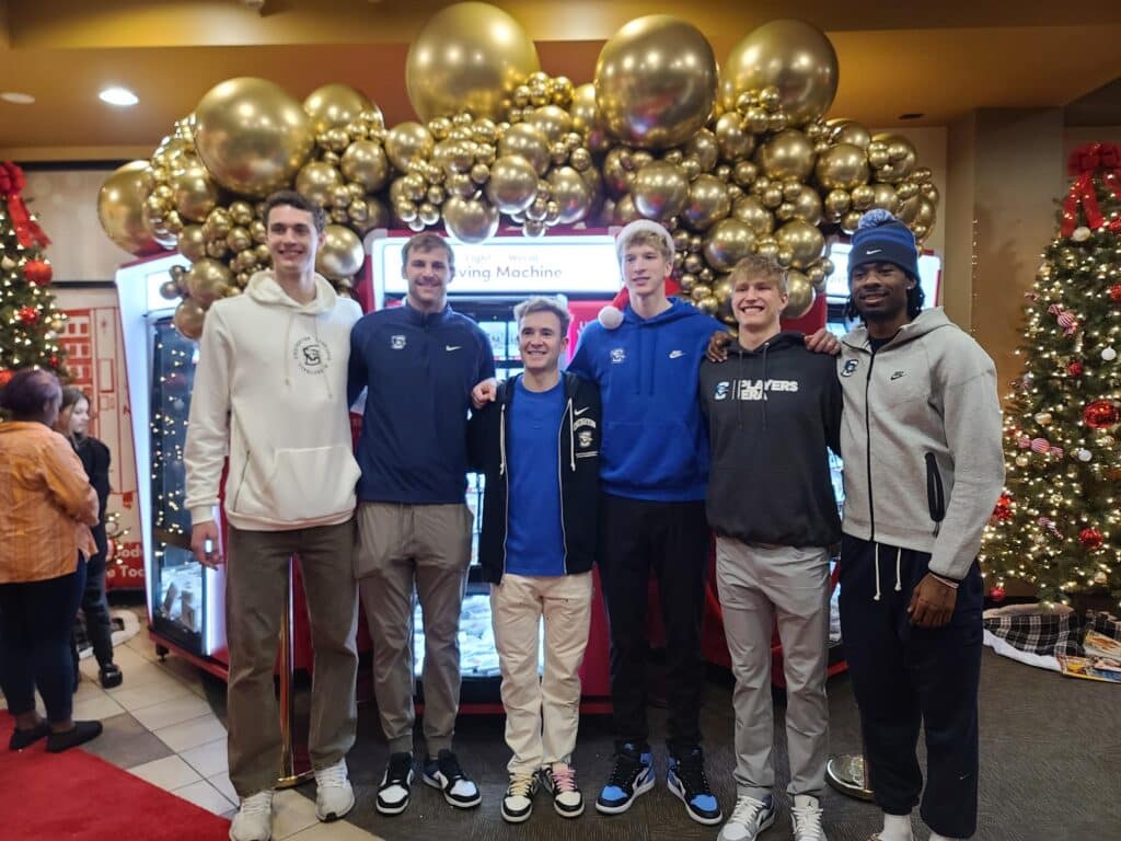 Ryan Kalkbrenner (left), Steven Ashworth (center) and other Creighton University basketball players at Giving Machine Omaha event