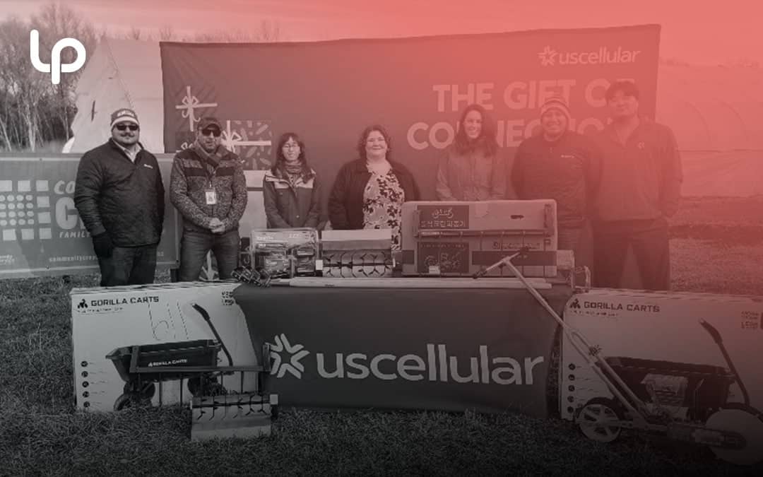 Community Crops volunteers standing behind UScellular donation table for Gift of Connection