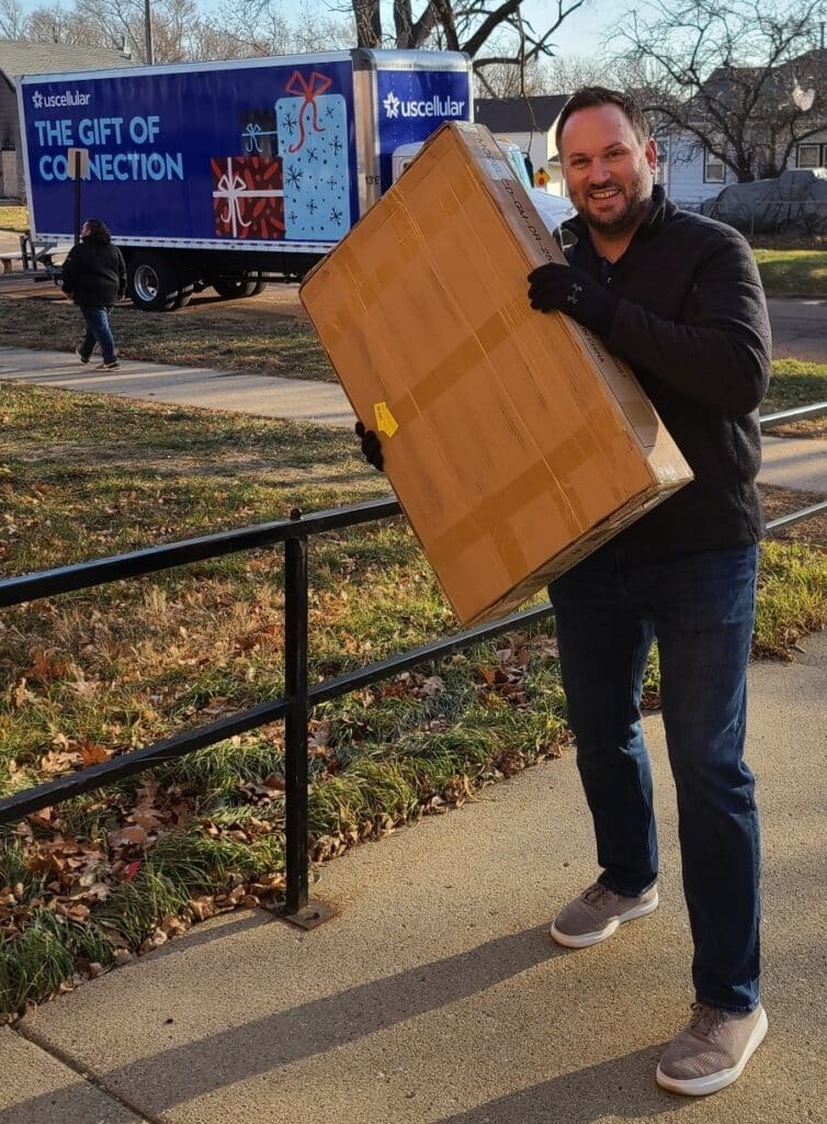 Chris from UScellular holding package to give to Gift of Connection truck