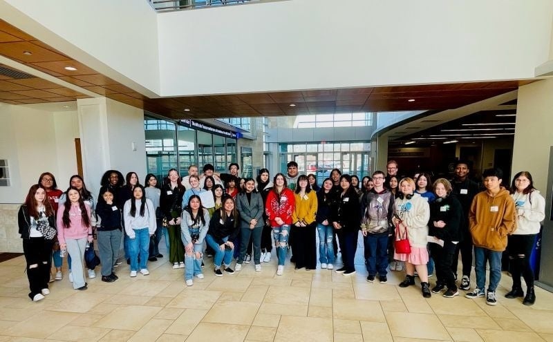 About 50 students posing at AIM Institute TRIO Day event in open room