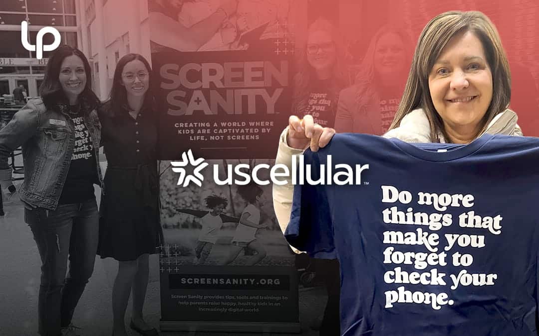 Parent holding up tshirt and group photo in front of event board for Screen Sanity Parent Night to support UScellular's Global Day of Unplugging campaign