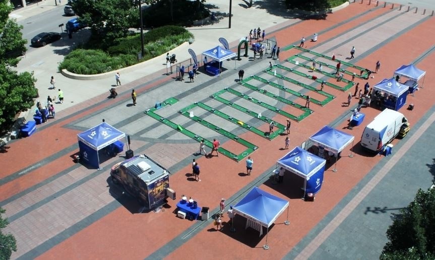 Aerial view of UScellular’s Unplug & Play event featuring a long, winding mini golf course and multiple blue event tents set up across a large outdoor plaza.